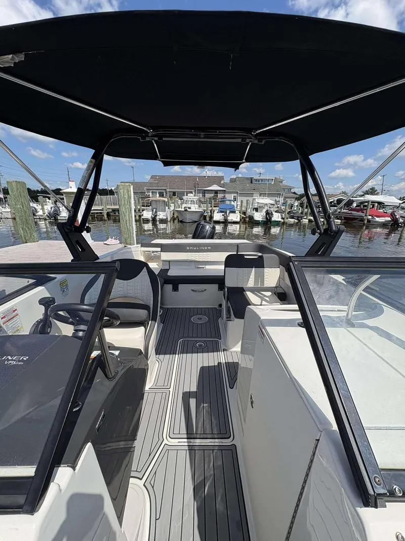 Slide: The Image of 2019 Bayliner VR6 boat interior with seating, canopy, and marina view. - 3