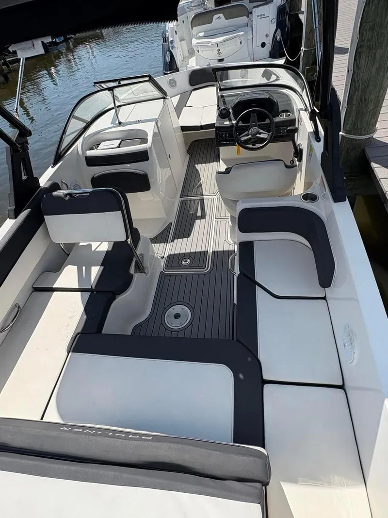 Slide: The Image of 2019 Bayliner VR6 boat interior with seating and steering wheel, docked by the water. - 5