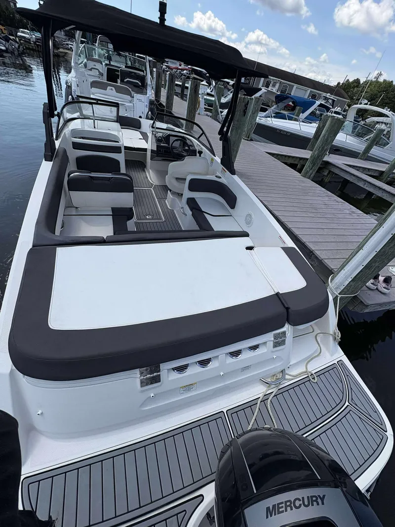 Slide: The Image of 2019 Bayliner VR6 boat docked, featuring spacious seating and Mercury outboard motor. - 7