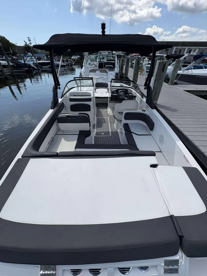 Slide: The Image of 2019 Bayliner VR6 boat with spacious seating, docked at a marina under a partly cloudy sky. - 8