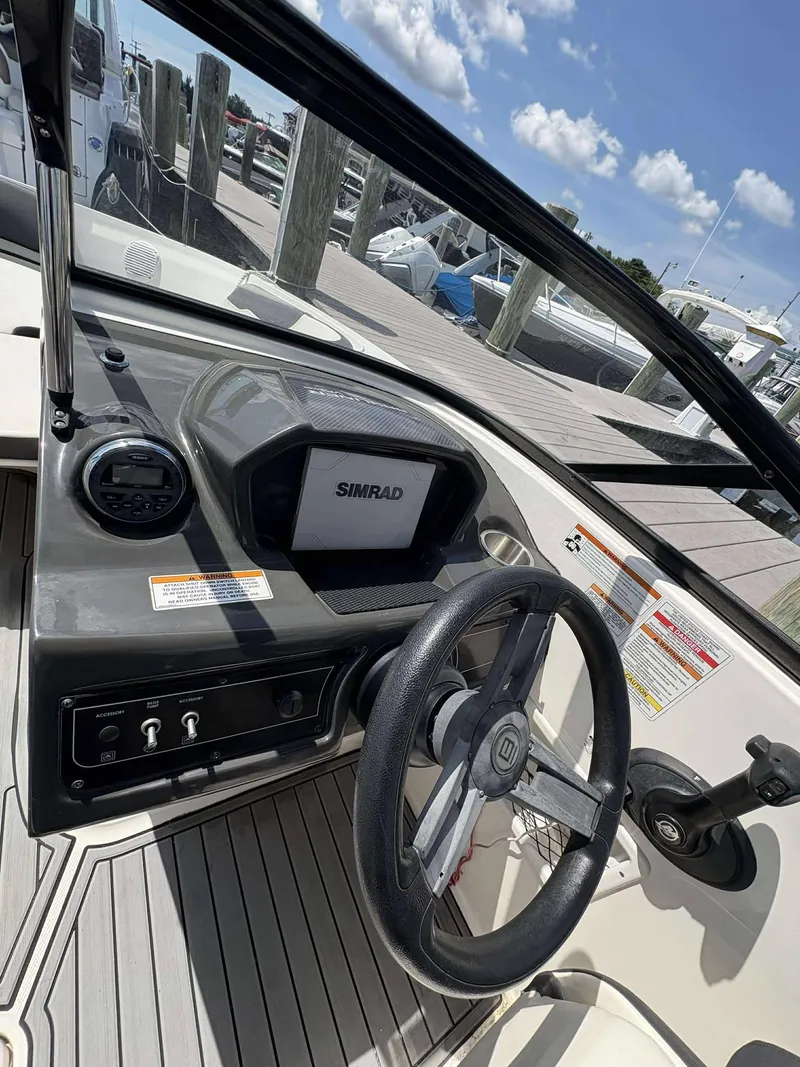 Slide: The Image of 2019 Bayliner VR6 boat dashboard with steering wheel and Simrad display. - 9