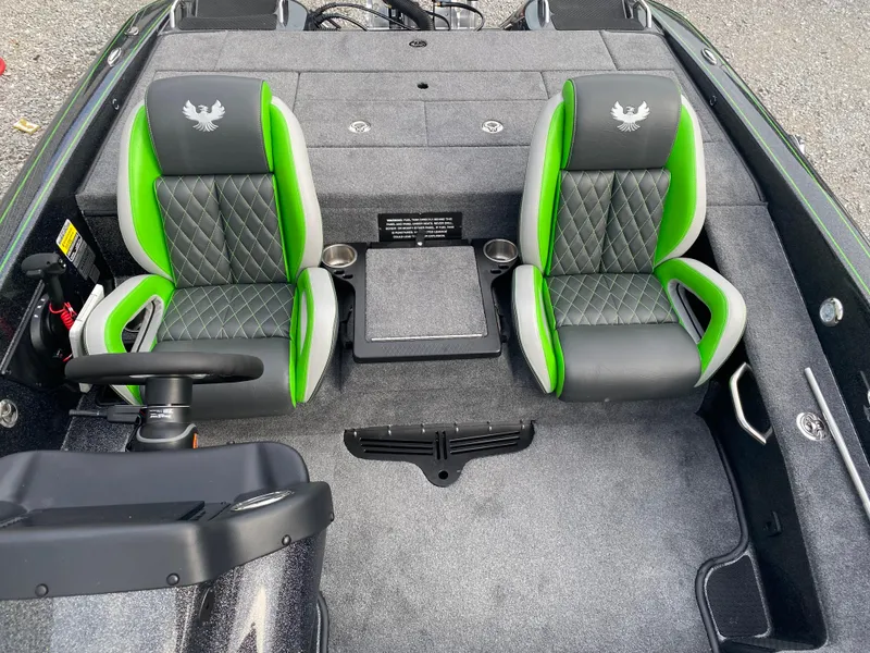Slide: The Image of 2025 Phoenix 818 Pro boat interior with green and gray seats, steering wheel, and carpeted flooring. - 17