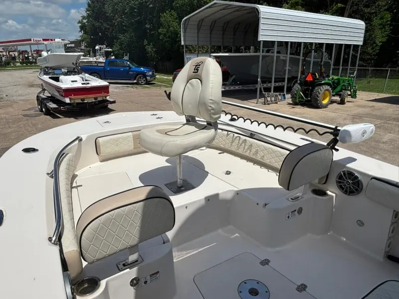 Slide: The Image of 2022 Carolina Skiff 26 Ultra Elite boat interior with seating and steering, parked outdoors. - 12
