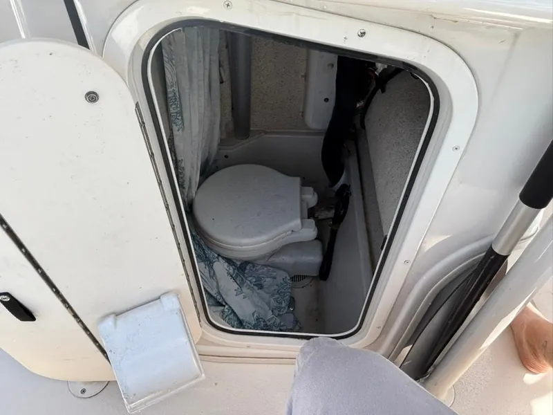 Slide: The Image of 2022 Carolina Skiff 26 Ultra Elite boat toilet compartment with open door. - 16
