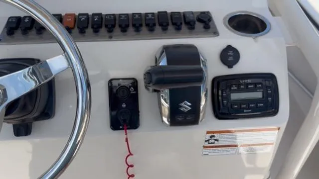 Slide: The Image of Control panel of 2022 Carolina Skiff 26 Ultra Elite boat with steering wheel and switches. - 17
