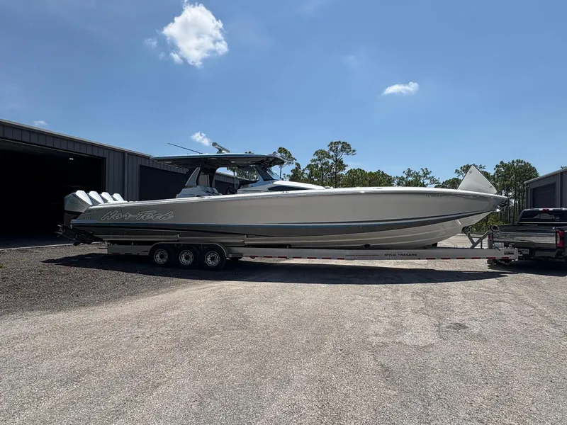 Slide: The Image of 2020 Nor-Tech 450 Sport Center Console boat on trailer, parked outdoors under clear sky. - 2