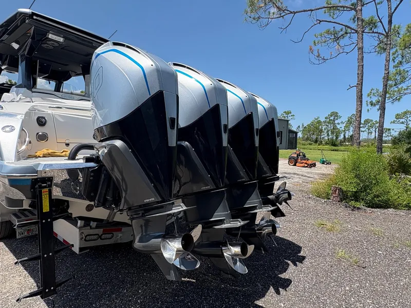 Slide: The Image of 2020 Nor-Tech 450 Sport Center Console with quad outboard engines, parked outdoors. - 4