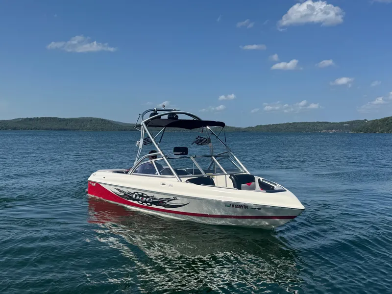 The Image of 2006 Tigé 22V boat on a lake under a clear blue sky. - 1