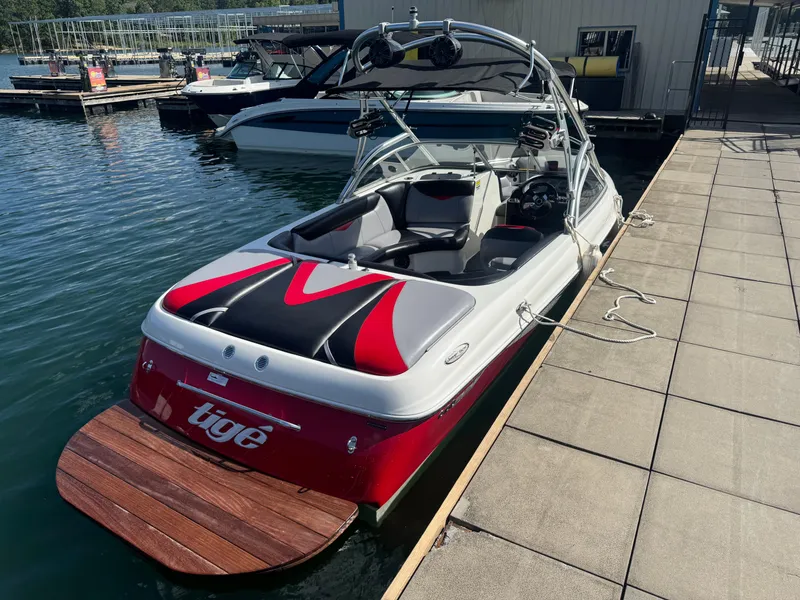 Slide: The Image of 2006 Tigé 22V boat docked, featuring sleek design and vibrant red accents. - 13