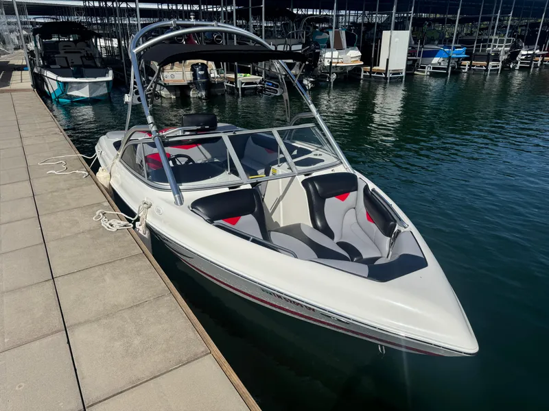 Slide: The Image of 2006 Tigé 22V boat docked at marina, featuring sleek design and spacious seating. - 14
