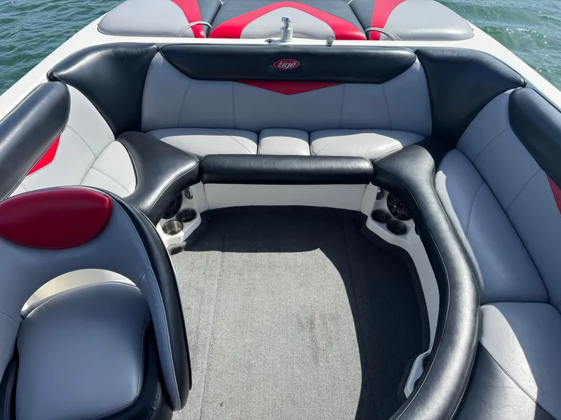 Slide: The Image of 2006 Tigé 22V boat interior with black, gray, and red seating, on water. - 6