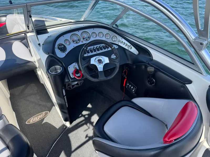 Slide: The Image of 2006 Tigé 22V boat cockpit with steering wheel and control panel on water. - 7