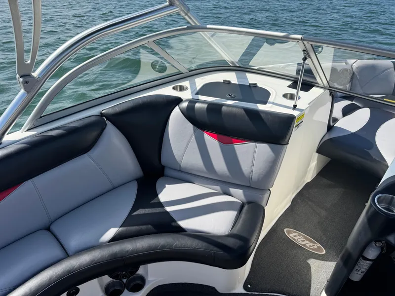 Slide: The Image of 2006 Tigé 22V boat interior with black and gray seating, on a sunny day. - 8