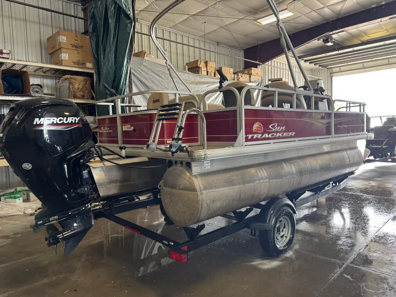 Slide: The Image of 2023 Sun Tracker Bass Buggy 18 DLX pontoon boat with Mercury engine in a garage. - 3