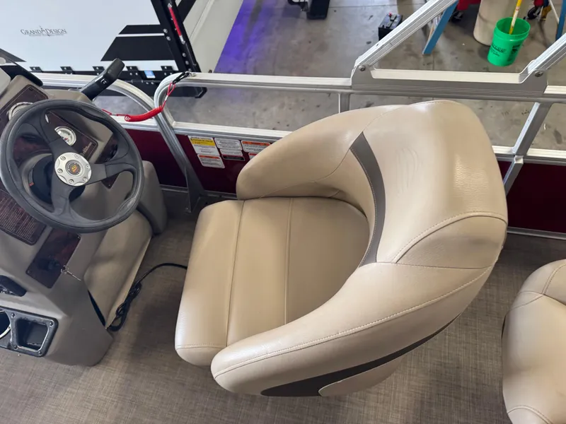 Slide: The Image of 2023 Sun Tracker Bass Buggy 18 DLX boat interior with steering wheel and beige captain's chair. - 7