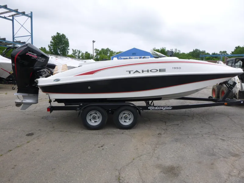 Slide: The Image of 2022 Tahoe 1950 boat on trailer, white and black design, parked outdoors. - 4
