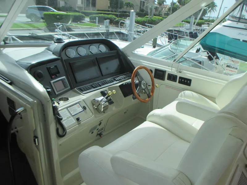 Slide: The Image of 2005 Sea Ray 390 Motor Yacht helm with modern navigation instruments and white leather seating. - 19