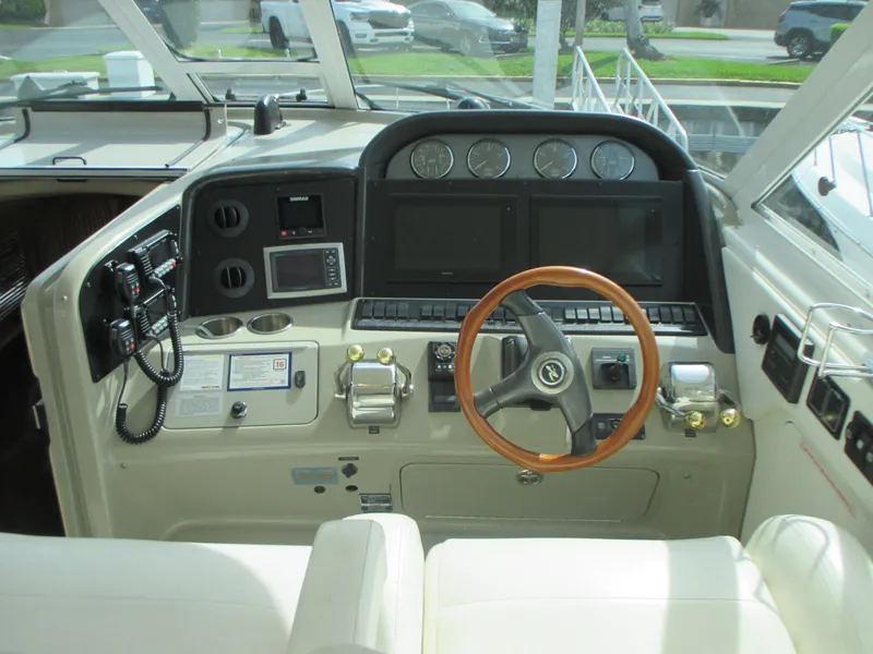 Slide: The Image of 2005 Sea Ray 390 Motor Yacht helm with modern navigation instruments and wooden steering wheel. - 20