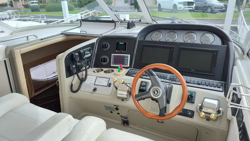 Slide: The Image of 2005 Sea Ray 390 Motor Yacht helm with modern navigation instruments and wooden steering wheel. - 21
