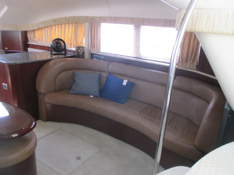 Slide: The Image of Interior of 2005 Sea Ray 390 Motor Yacht with curved leather seating and pillows. - 26