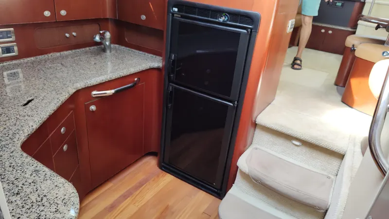 Slide: The Image of 2005 Sea Ray 390 Motor Yacht kitchen with granite countertops and black refrigerator. - 37