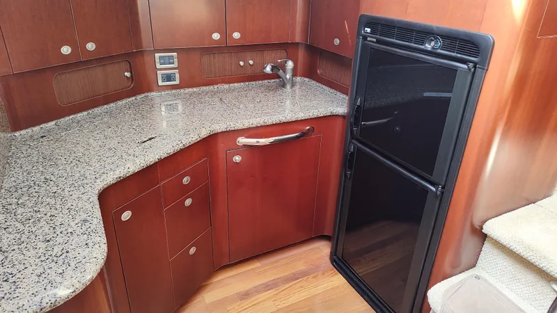 Slide: The Image of 2005 Sea Ray 390 Motor Yacht kitchen with granite countertops and black refrigerator. - 38