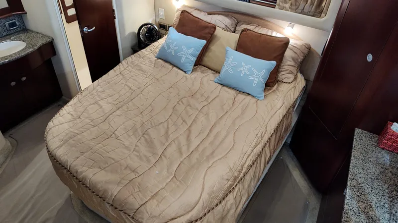 Slide: The Image of 2005 Sea Ray 390 Motor Yacht bedroom with a cozy bed and decorative pillows. - 48