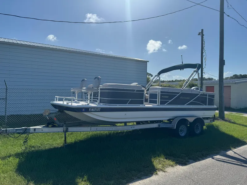 Slide: The Image of 2018 Hurricane FunDeck 226F OB boat on trailer, parked outdoors under clear sky. - 0