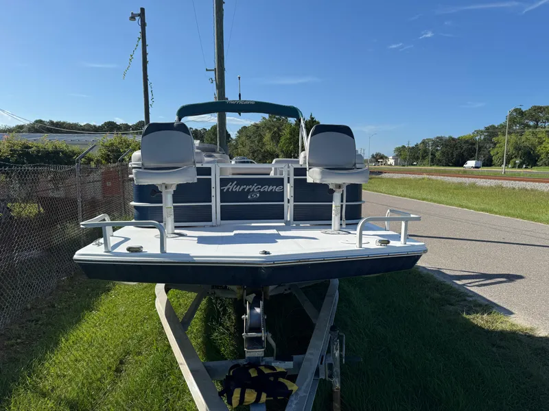 Slide: The Image of 2018 Hurricane FunDeck 226F OB boat on trailer, parked roadside under clear blue sky. - 11