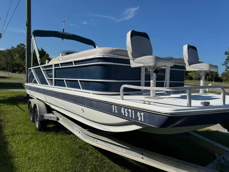 Slide: The Image of 2018 Hurricane FunDeck 226F OB boat on trailer, parked on grass under clear blue sky. - 19