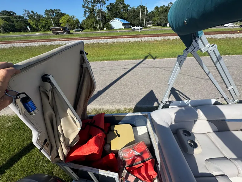 Slide: The Image of 2018 Hurricane FunDeck 226F OB boat storage with life jackets and accessories, sunny day. - 6