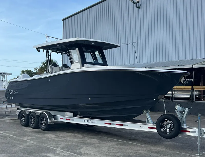 Slide: The Image of 2025 Robalo R300 Center Console boat on trailer, parked outdoors. - 10