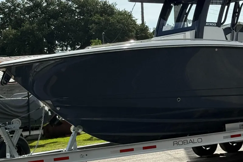 Slide: The Image of 2025 Robalo R300 Center Console boat on trailer, side view. - 13