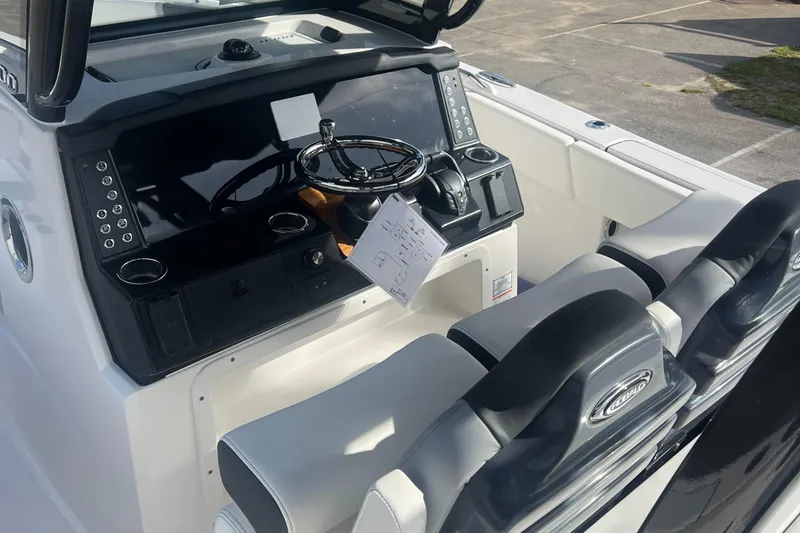 Slide: The Image of 2025 Robalo R300 Center Console boat dashboard with steering wheel and controls. - 17