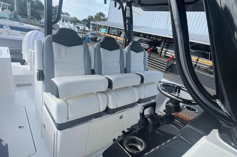Slide: The Image of 2025 Robalo R300 Center Console boat interior with three cushioned seats and steering console. - 20