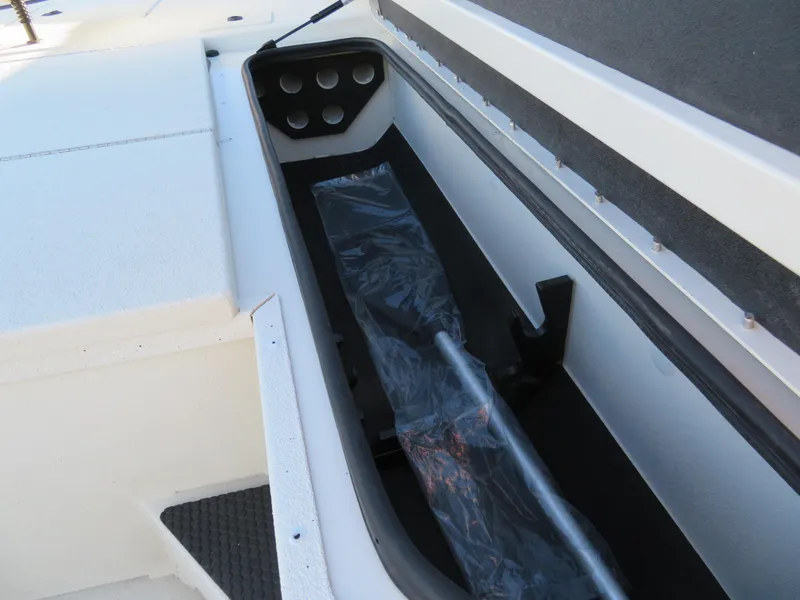 Slide: The Image of 2024 Ranger RB200 boat storage compartment with rod holders and protective cover. - 11