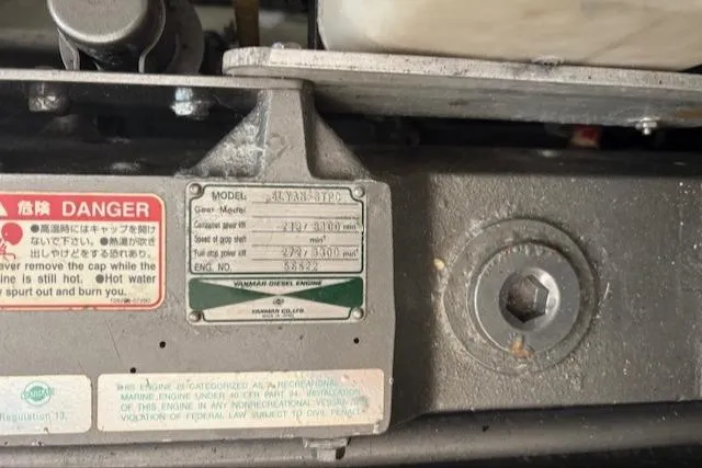 Slide: The Image of Engine label on a 2006 Mainship 400 Trawler, displaying specifications and safety warnings. - 11