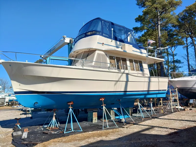 Slide: The Image of 2006 Mainship 400 Trawler on stands, blue hull, outdoor setting, clear sky. - 13