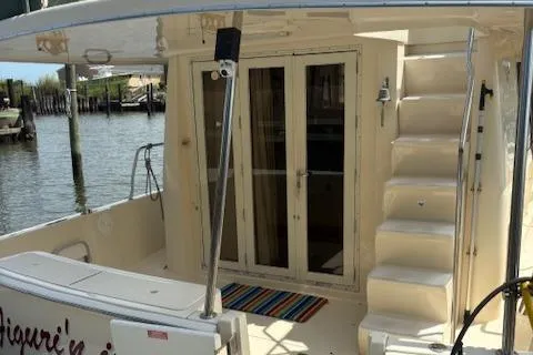 Slide: The Image of 2006 Mainship 400 Trawler, rear deck view with stairs and glass doors. - 2