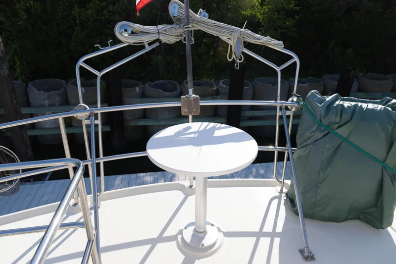 Slide: The Image of 2006 Mainship 400 Trawler deck with railing, table, and covered equipment. - 22