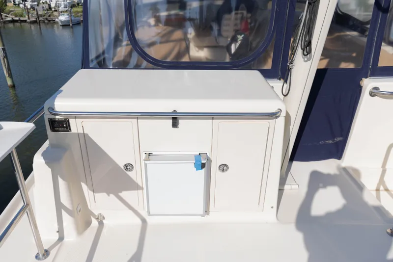 Slide: The Image of 2006 Mainship 400 Trawler deck with storage compartments and railing, dockside view. - 23