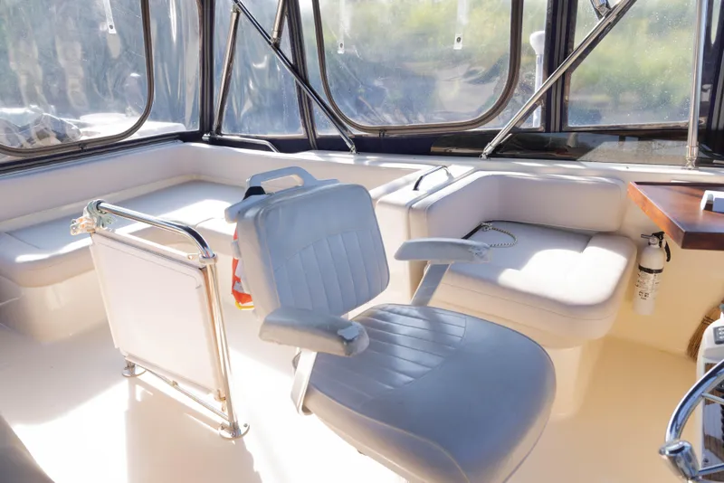 Slide: The Image of 2006 Mainship 400 Trawler interior with seating and windows, featuring a captain's chair and safety equipment. - 29