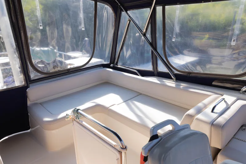 Slide: The Image of 2006 Mainship 400 Trawler interior with cushioned seating and clear windows. - 30