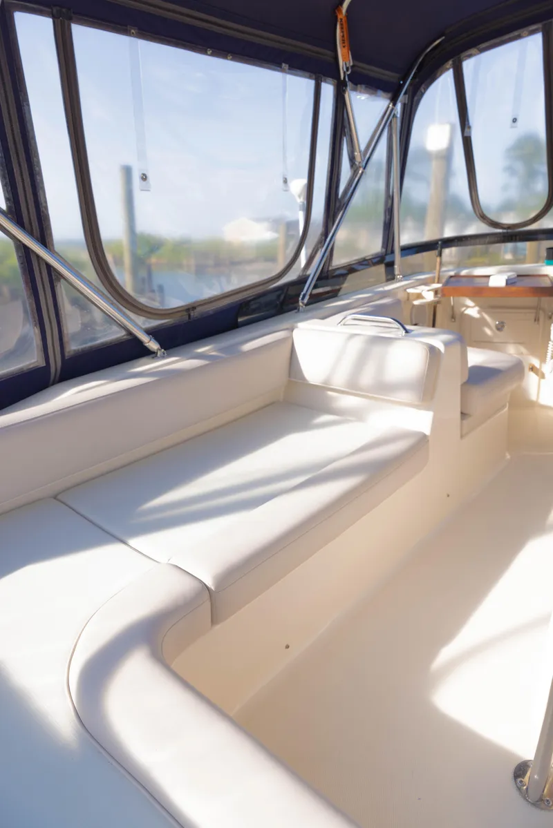 Slide: The Image of 2006 Mainship 400 Trawler interior with white seating and large windows. - 32