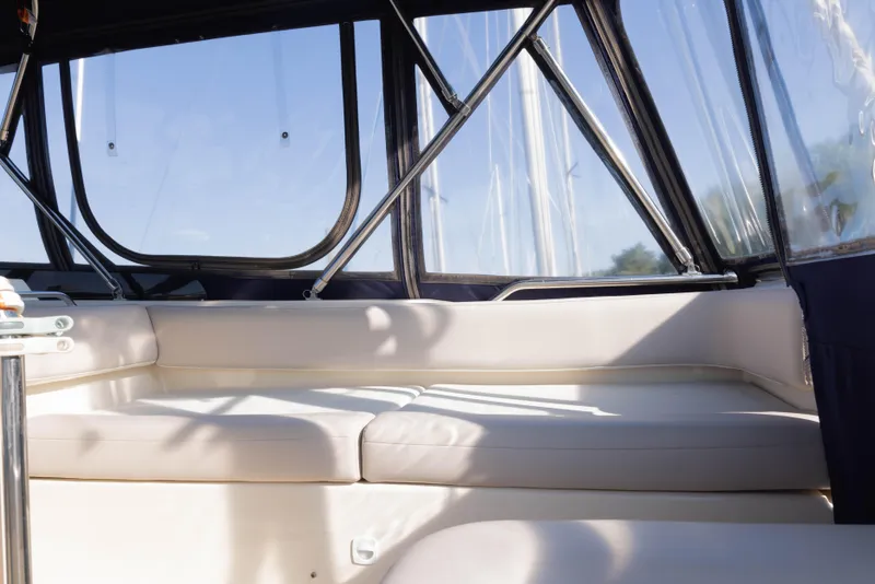 Slide: The Image of Interior seating area of a 2006 Mainship 400 Trawler with cushioned seats and windows. - 34