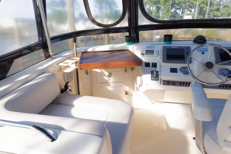 Slide: The Image of 2006 Mainship 400 Trawler helm with steering wheel, navigation controls, and seating. - 35