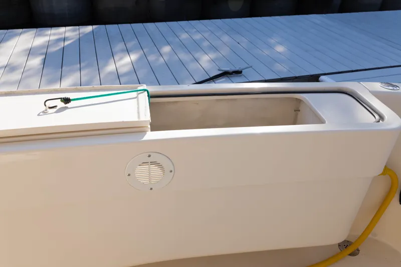 Slide: The Image of 2006 Mainship 400 Trawler deck detail with storage compartment and dock background. - 41