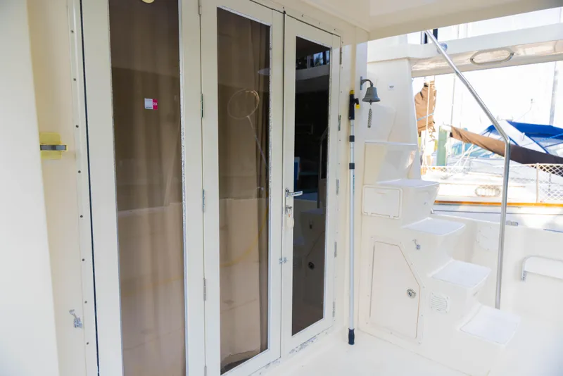 Slide: The Image of 2006 Mainship 400 Trawler exterior with glass doors and steps, showcasing nautical design. - 43