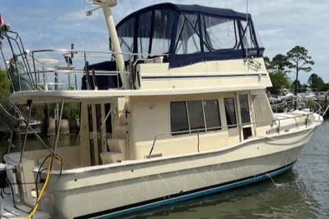 Slide: The Image of 2006 Mainship 400 Trawler docked, featuring a spacious upper deck and classic design. - 5