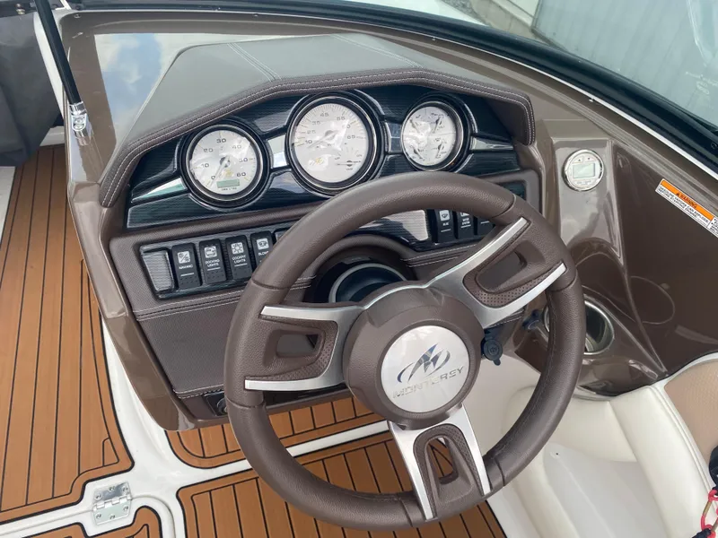 Slide: The Image of Steering wheel and dashboard of 2018 Monterey 224FS boat with wood accents. - 12